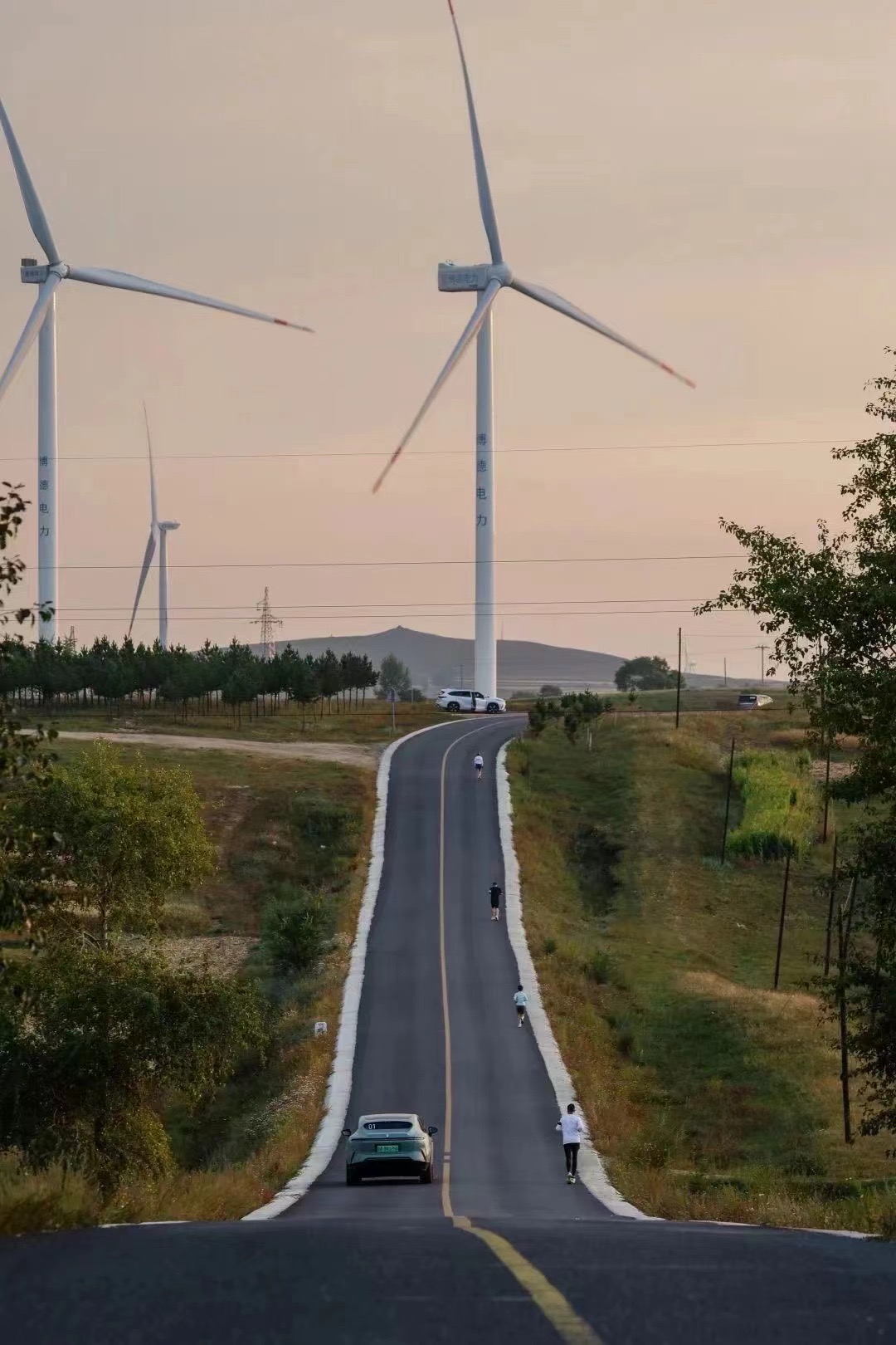 Runners on the race route with wind turbines in the background